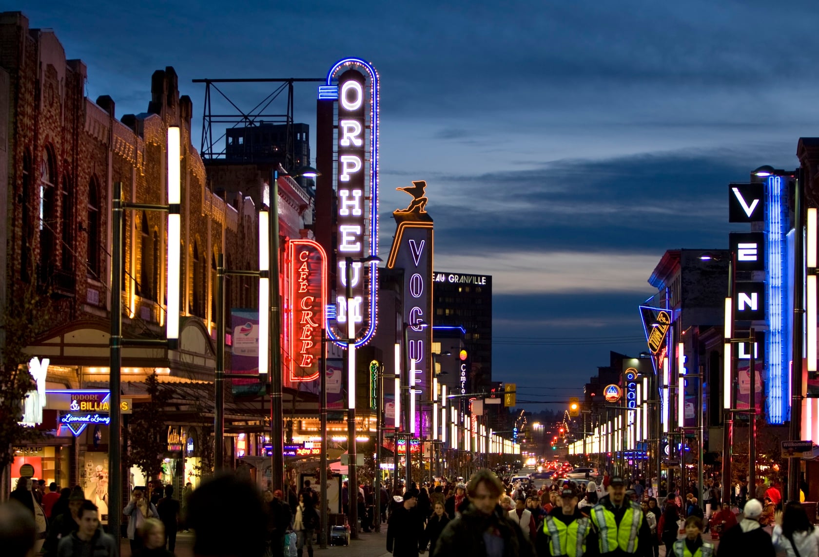 Granville Street — neon strip glowing in the wet at blue hour
